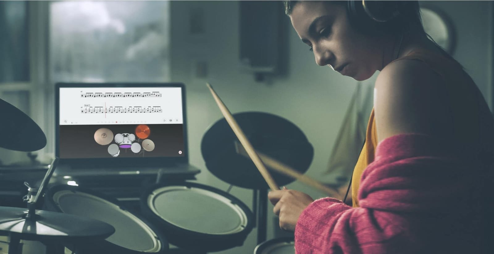 Batteuse jouant avec les partitions interactives Tomplay affichées sur un ordinateur portable