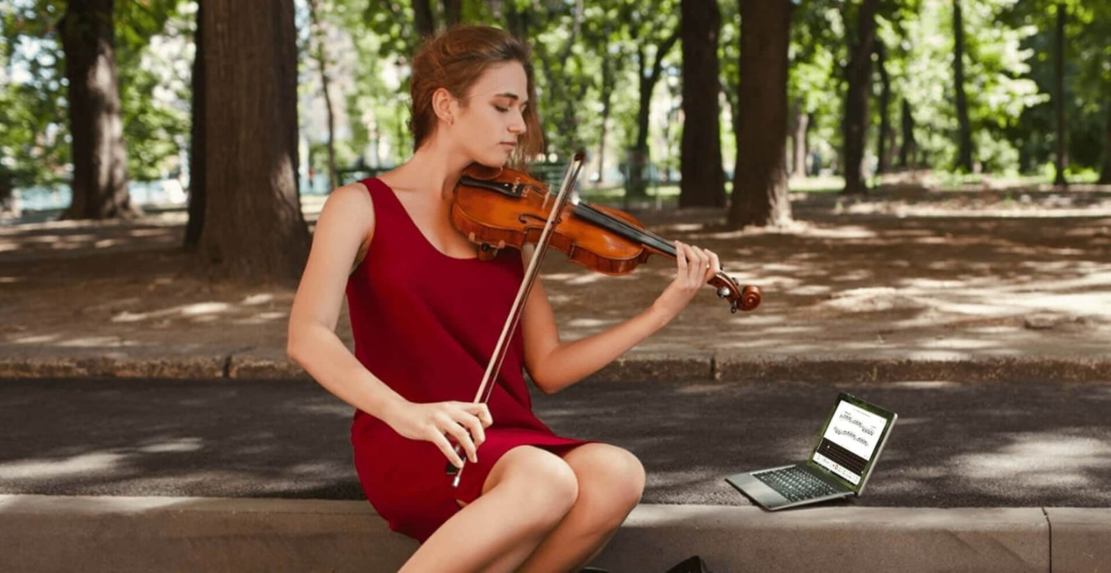Violoniste jouant avec les partitions interactives Tomplay sur un ordinateur portable
